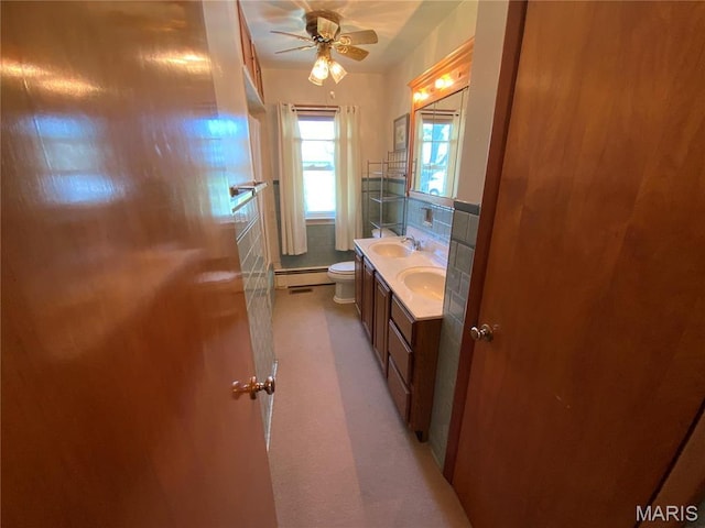 401 Edinger Rd, Wentzville, MO 63385 - bathroom with a baseboard heating unit, toilet, double vanity, and a ceiling fan