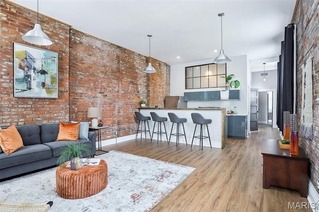 2713 Utah St, Saint Louis, MO 63118 - living area with wood finished floors, brick wall, baseboards, and recessed lighting