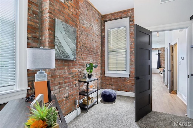 2713 Utah St, Saint Louis, MO 63118 - hallway with brick wall, baseboards, plenty of natural light, and carpet