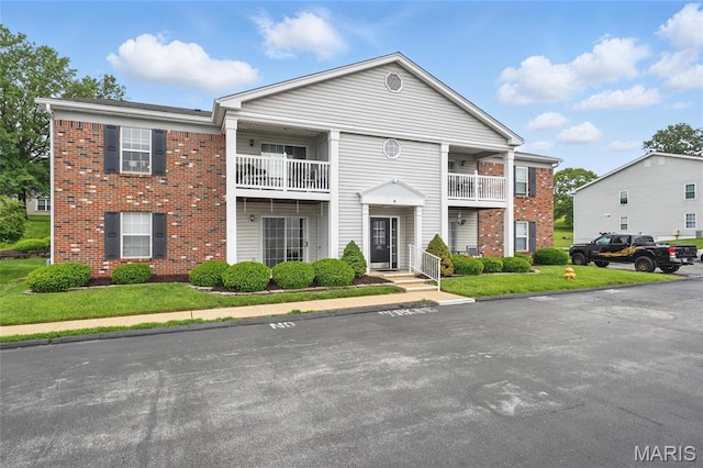 9 Berview Cir Unit H, Saint Louis, MO 63129 - neoclassical / greek revival house featuring a balcony, brick siding, and a front yard