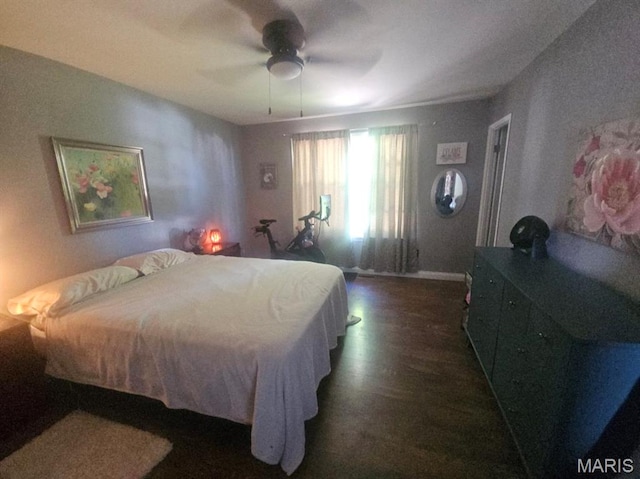 bedroom with dark wood-style floors, a ceiling fan, and baseboards