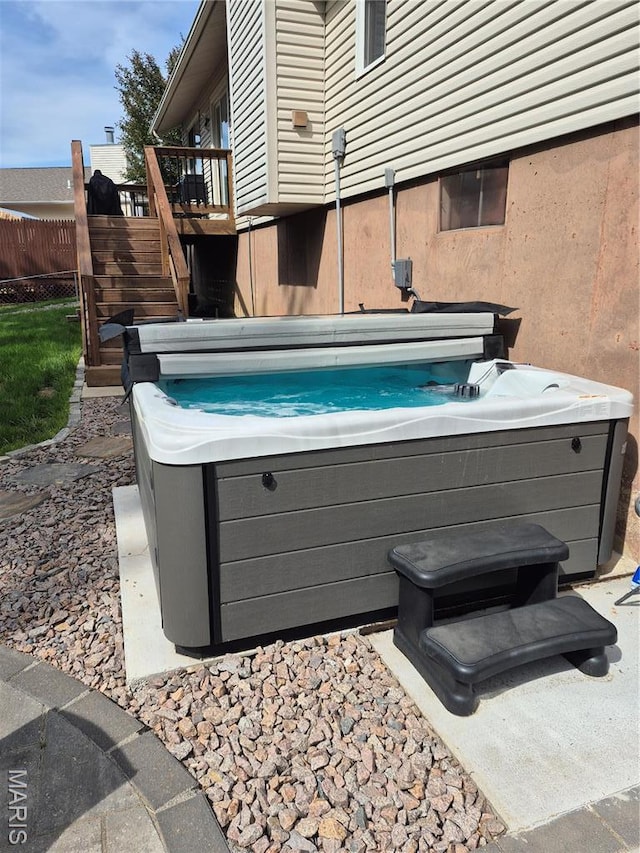 view of pool featuring a hot tub, stairway, fence, and a deck