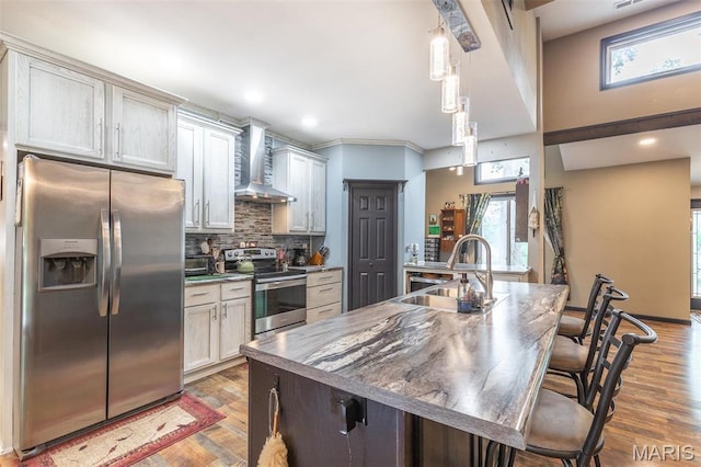 732 N Main St, Poplar Bluff, MO 63901 - kitchen with appliances with stainless steel finishes, wall chimney exhaust hood, a sink, backsplash, and light wood-style floors