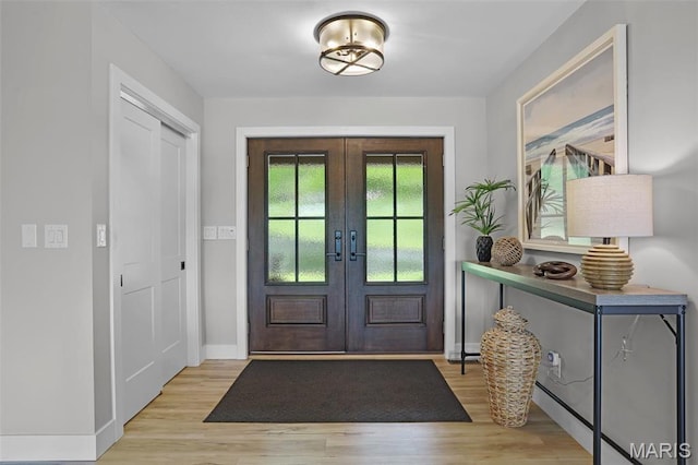 entrance foyer featuring french doors, light wood-style flooring, and baseboards