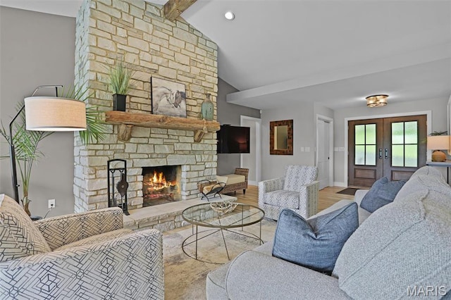 living area featuring french doors, a fireplace, wood finished floors, and baseboards