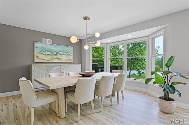 dining area with baseboards and light wood-style floors