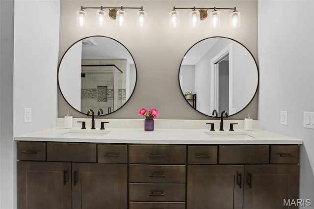 bathroom with double vanity and a tile shower