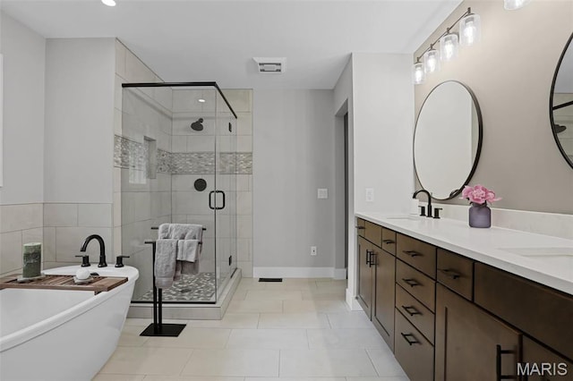 bathroom featuring a stall shower, a freestanding bath, double vanity, tile patterned floors, and recessed lighting
