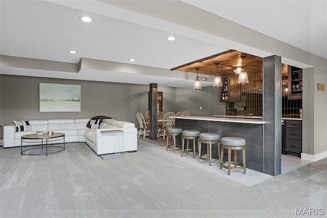 indoor wet bar featuring light colored carpet, recessed lighting, baseboards, and pendant lighting