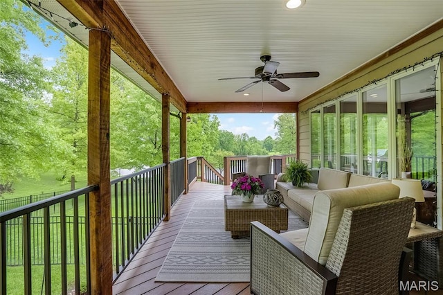 wooden terrace featuring a ceiling fan and an outdoor living space