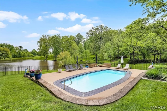 view of swimming pool featuring a water view, a patio area, and view of wooded area