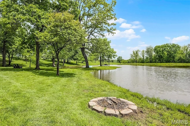 view of property's community featuring a fire pit, a yard, and a water view