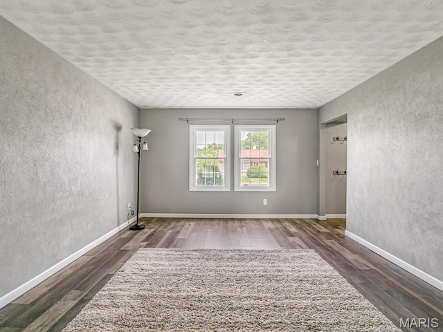 605 S Ridge Ave, Steeleville, IL 62288 - spare room with wood-type flooring, a textured wall, baseboards, and a textured ceiling
