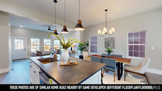 3229 Portis Ave, Saint Louis, MO 63116 - kitchen with a sink, a chandelier, dark countertops, open floor plan, and white cabinetry