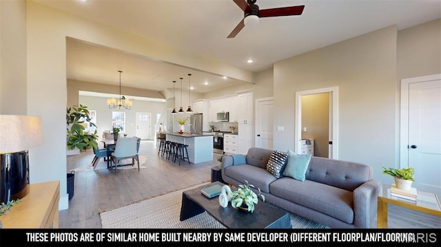 3229 Portis Ave, Saint Louis, MO 63116 - living room featuring light wood-style floors, ceiling fan, recessed lighting, and a chandelier