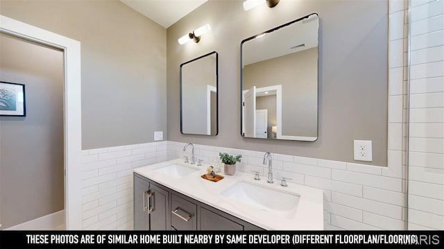 3229 Portis Ave, Saint Louis, MO 63116 - full bathroom featuring double vanity, tile walls, and wainscoting