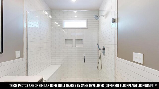 3229 Portis Ave, Saint Louis, MO 63116 - bathroom featuring a stall shower, tile walls, vanity, and a wainscoted wall