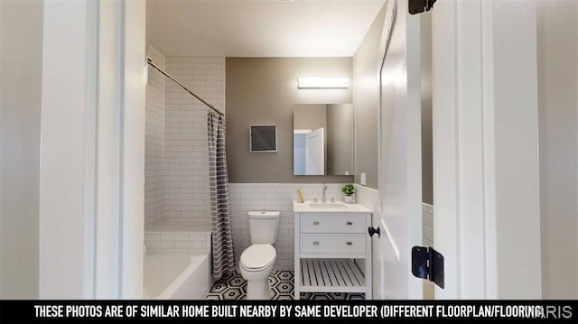 3229 Portis Ave, Saint Louis, MO 63116 - full bathroom featuring tile walls, toilet, vanity, tile patterned flooring, and shower / bath combo with shower curtain