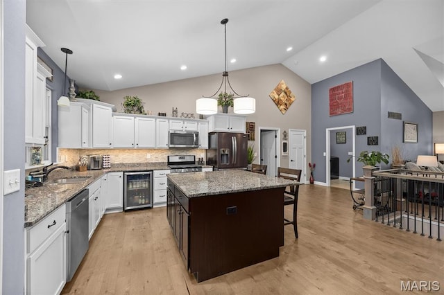 409 Briar Creek Rd, Troy, IL 62294 - kitchen featuring wine cooler, stainless steel appliances, a sink, high vaulted ceiling, and a center island