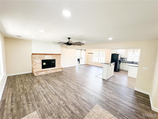 906 E Pace St, Salem, MO 65560 - unfurnished living room featuring baseboards, light wood-type flooring, ceiling fan, recessed lighting, and a stone fireplace