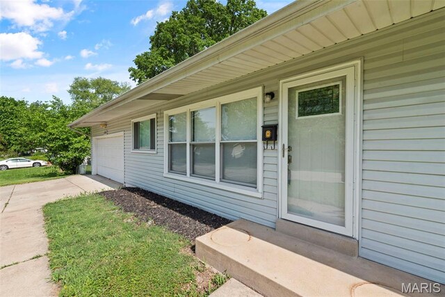 1095 Rogers Ln, Florissant, MO 63033 - view of side of home with driveway and an attached garage