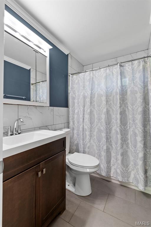 1095 Rogers Ln, Florissant, MO 63033 - bathroom with tile patterned floors, vanity, toilet, and tile walls