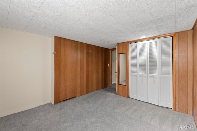 1095 Rogers Ln, Florissant, MO 63033 - unfurnished bedroom with carpet floors, wood walls, and a closet
