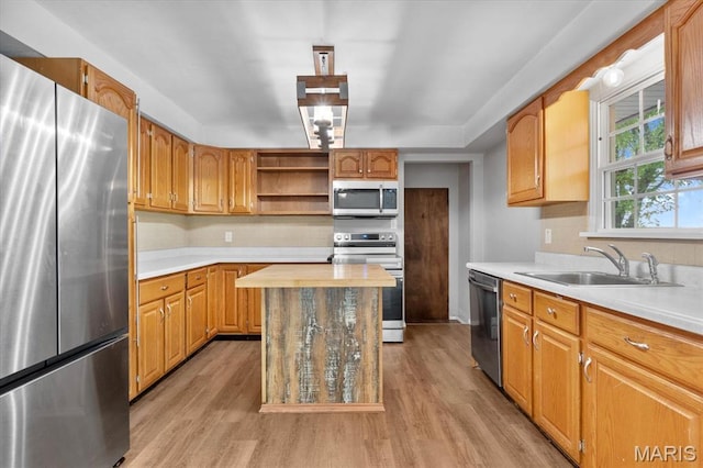 kitchen with stainless steel appliances, a sink, light wood-style flooring, open shelves, and decorative backsplash