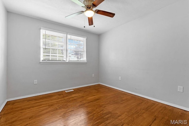 unfurnished room with wood finished floors, baseboards, and ceiling fan
