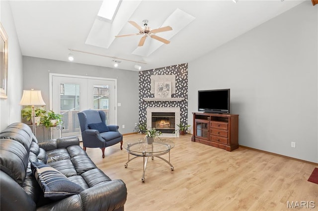 51 Sugar Ridge Ct, Saint Peters, MO 63376 - living room featuring a skylight, light wood-style flooring, vaulted ceiling, a fireplace, and rail lighting