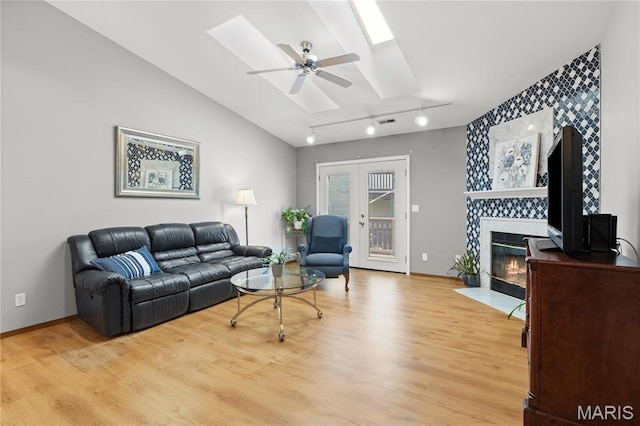 51 Sugar Ridge Ct, Saint Peters, MO 63376 - living area with a skylight, light wood finished floors, a tiled fireplace, track lighting, and ceiling fan