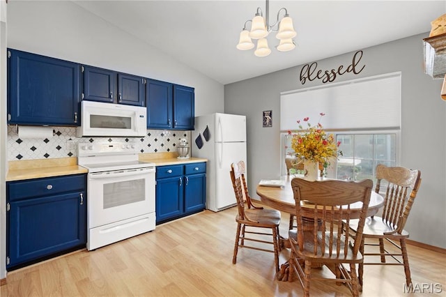 51 Sugar Ridge Ct, Saint Peters, MO 63376 - kitchen with white appliances, blue cabinetry, a chandelier, vaulted ceiling, and tasteful backsplash