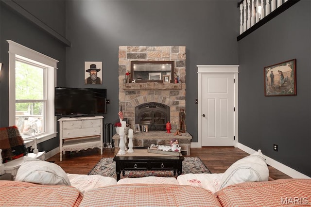 7877 Sylvan Pl, Dittmer, MO 63023 - living room featuring a high ceiling, baseboards, radiator, wood finished floors, and a fireplace