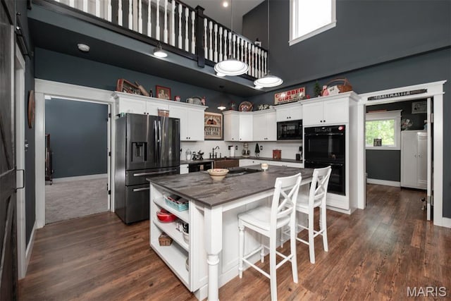 7877 Sylvan Pl, Dittmer, MO 63023 - kitchen with black appliances, a towering ceiling, open shelves, a center island, and white cabinetry