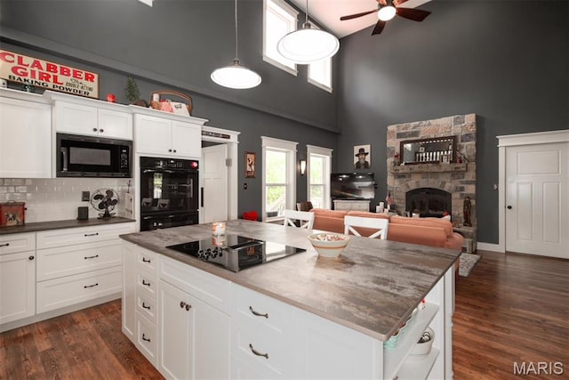 7877 Sylvan Pl, Dittmer, MO 63023 - kitchen with black appliances, high vaulted ceiling, ceiling fan, a fireplace, and hanging light fixtures
