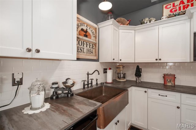 7877 Sylvan Pl, Dittmer, MO 63023 - kitchen featuring white cabinets, tasteful backsplash, a sink, and dark stone countertops