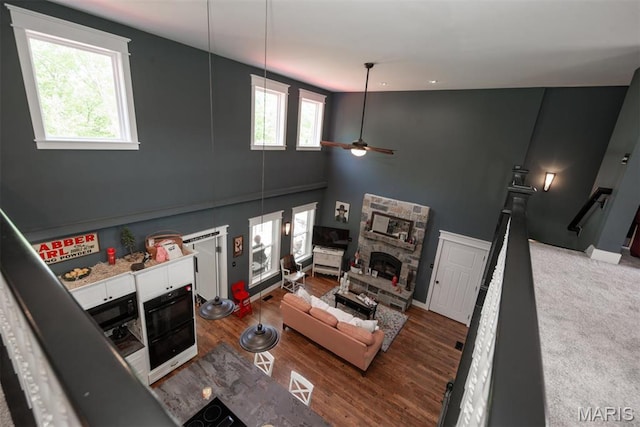 7877 Sylvan Pl, Dittmer, MO 63023 - living area with ceiling fan, a stone fireplace, wood finished floors, and a high ceiling