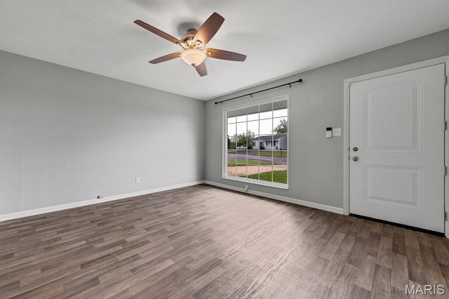 spare room with wood finished floors, ceiling fan, and baseboards
