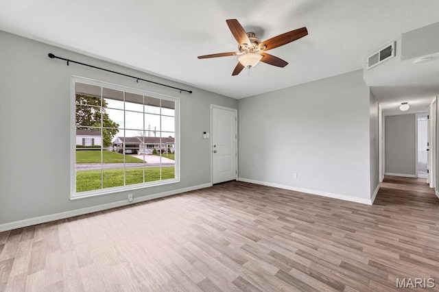 unfurnished room with wood finished floors, baseboards, and a ceiling fan
