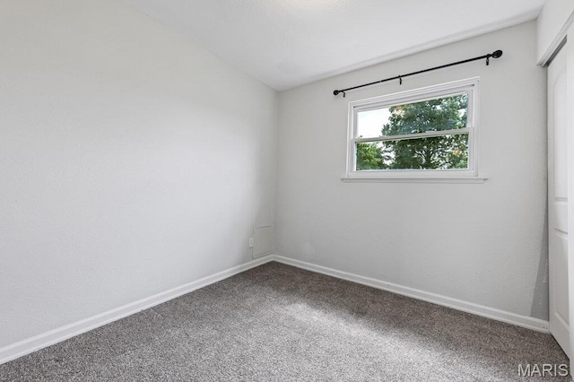unfurnished room with carpet flooring and baseboards