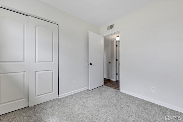 unfurnished bedroom featuring carpet flooring, a closet, and baseboards