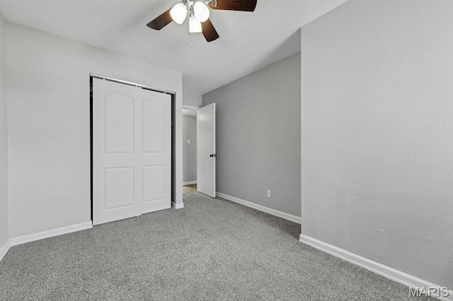 unfurnished bedroom featuring carpet flooring, a closet, baseboards, and a ceiling fan