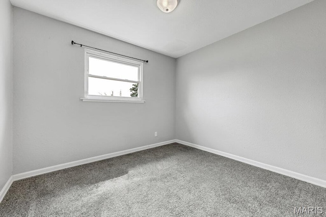 empty room featuring carpet floors and baseboards