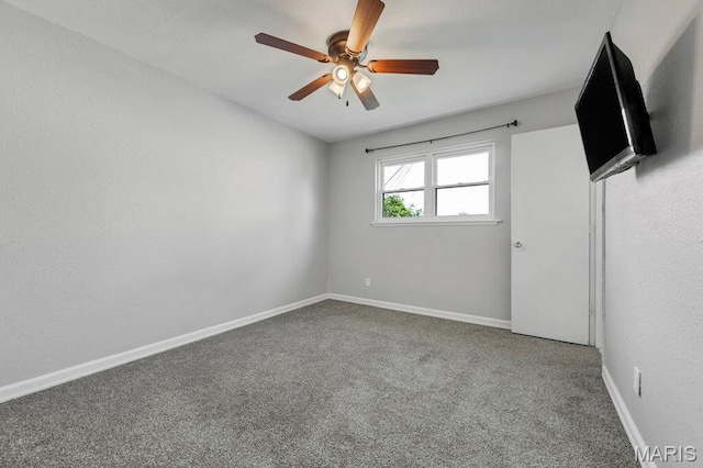 empty room with a ceiling fan, carpet, and baseboards