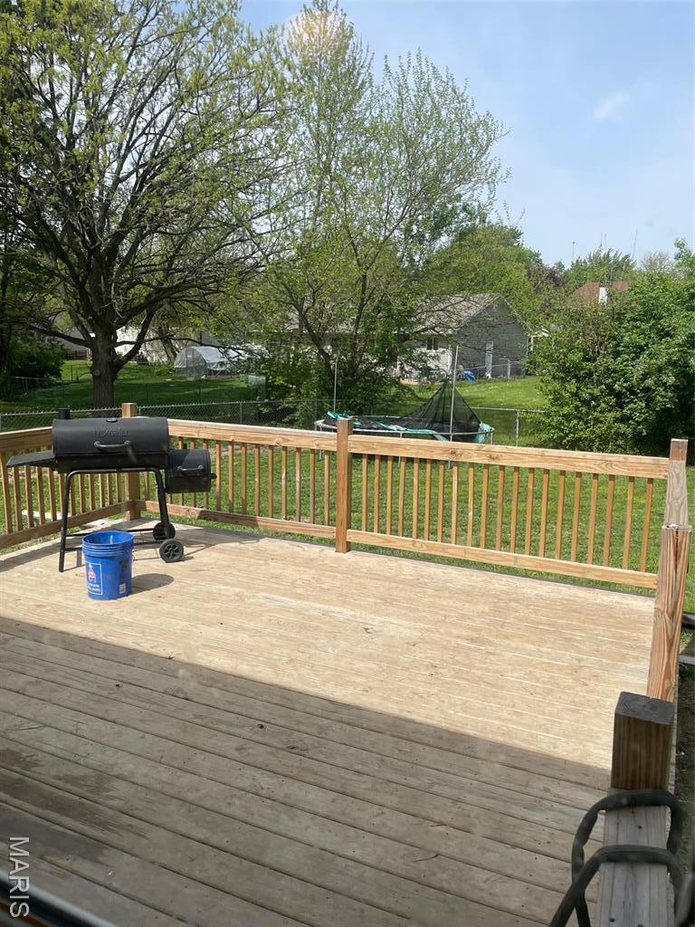 wooden deck with a yard and area for grilling