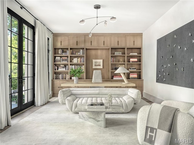 132 N Brentwood Blvd, Clayton, MO 63105 - living room featuring french doors, built in shelves, and a chandelier