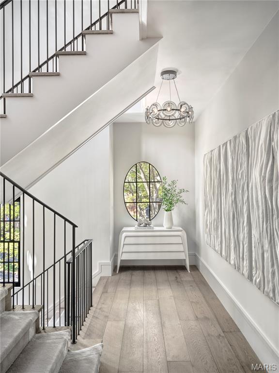132 N Brentwood Blvd, Clayton, MO 63105 - stairway with hardwood / wood-style flooring, a chandelier, and a high ceiling