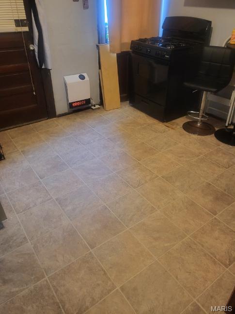 detailed view of black range with gas stovetop and freestanding refrigerator