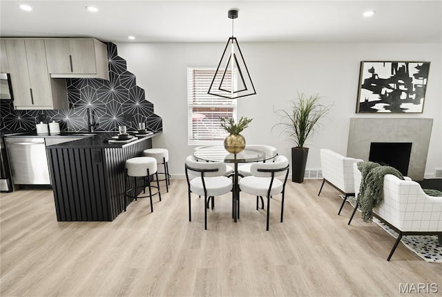 7544 Melrose Ave, University City, MO 63130 - dining room with light wood-style floors, recessed lighting, a premium fireplace, and baseboards