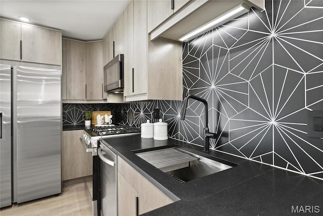 7544 Melrose Ave, University City, MO 63130 - kitchen featuring stainless steel appliances, a sink, light brown cabinets, dark countertops, and tasteful backsplash